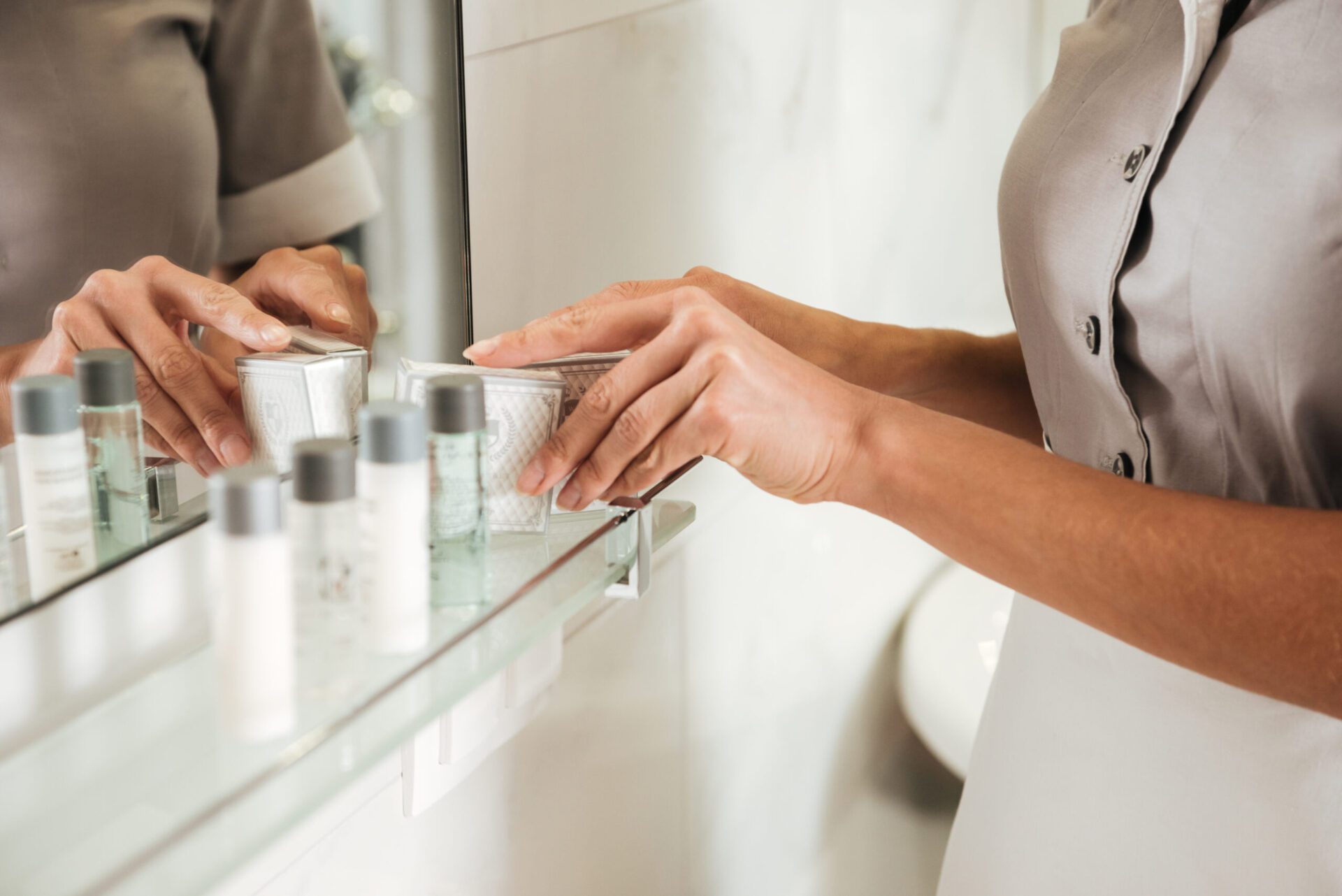 Image of hotel staff placing hotel toiletries on the counter